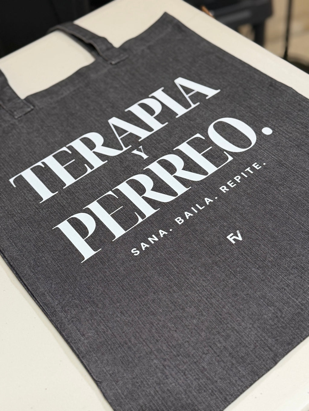 Close-up of Terapia y Perreo black denim tote bag